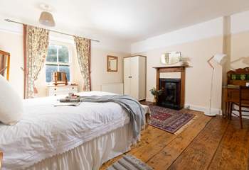 This gorgeous large bedroom has a stunning ornamental fire place. 