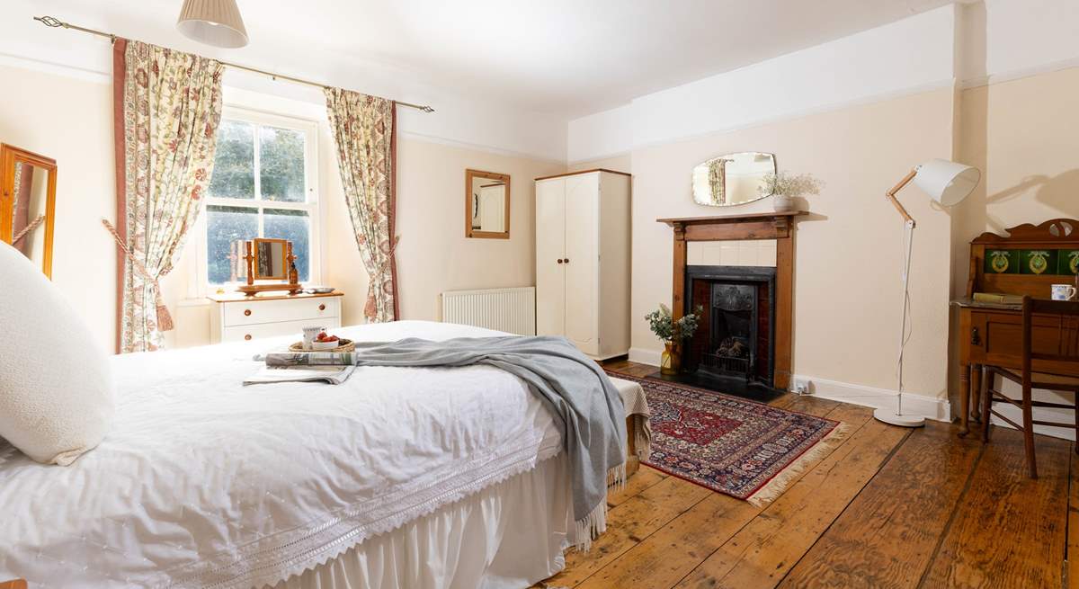 This gorgeous large bedroom has a stunning ornamental fire place. 