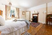 This gorgeous large bedroom has a stunning ornamental fire place.