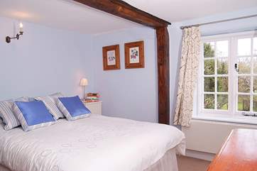 This tranquil double bedroom looks out over the garden at the back of the cottage.