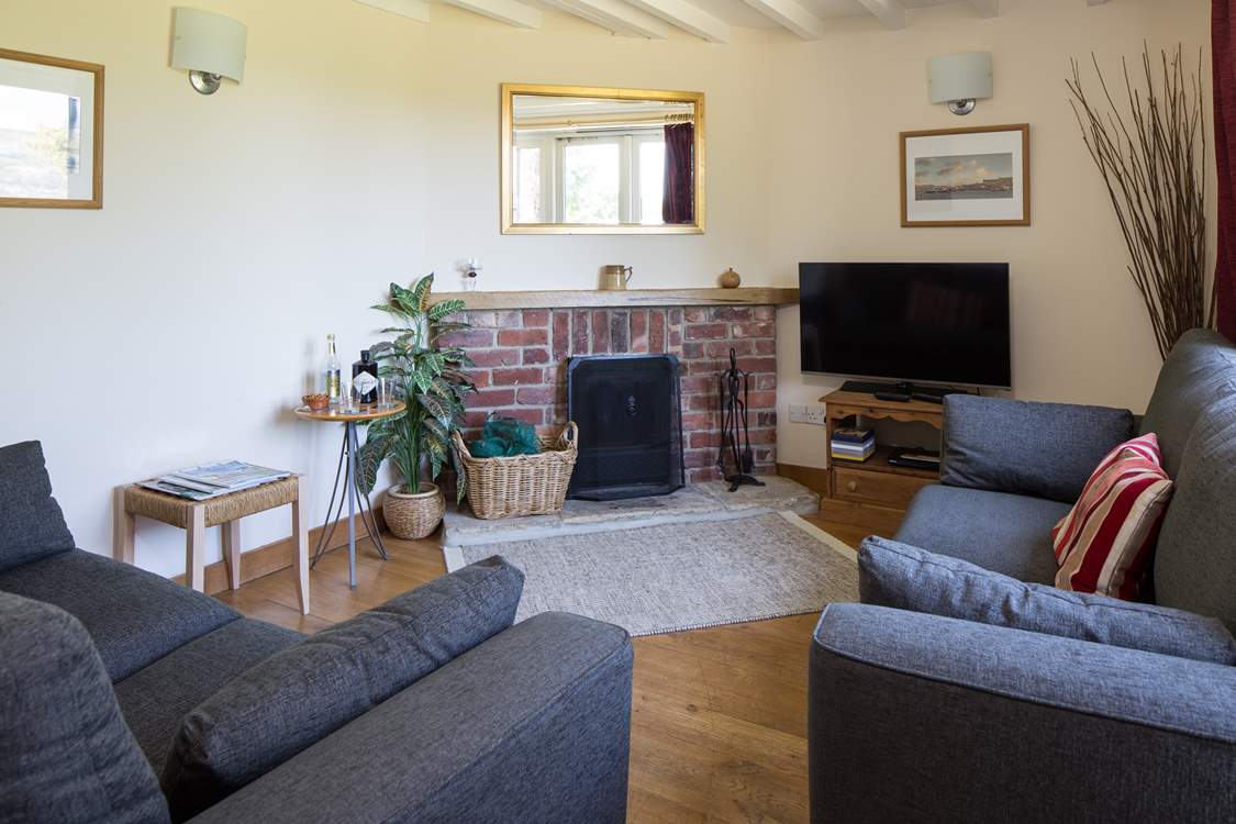 The cosy sitting-room has comfortable sofas and a wood-burner making this cottage a great choice out-of-season.