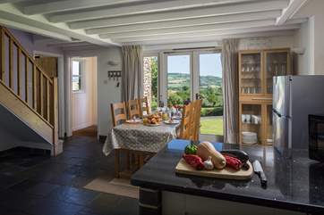 This is the open plan dining and kitchen-area. The steps lead up to the main sitting-room and from there French windows to the patio.