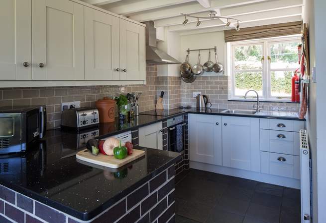 The kitchen is in one corner of the open plan living space and is very well-equipped. The window looks out onto the enclosed rear courtyard.