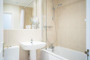 The well-appointed family bathroom has a bath with fitted shower above.