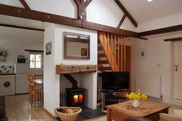 The L-shaped open plan living-room includes a welcoming wood-burner at the centre.