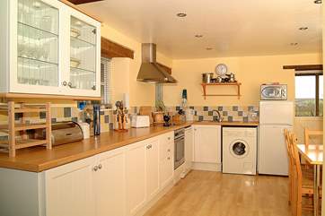 The kitchen and dining-area, with the stable-door at the end opening onto the deck in front of the cottage.
