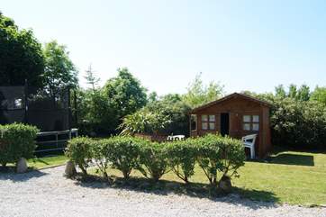 The shared play-area opposite the cottage includes a summer-house and a children's trampoline.