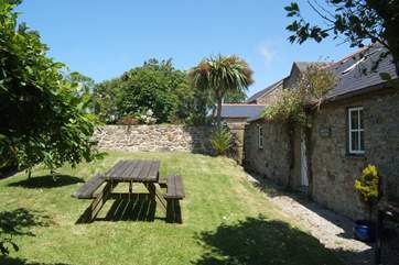 The cottage garden is bordered by mature hedges and shrubs and a lovely stone wall.