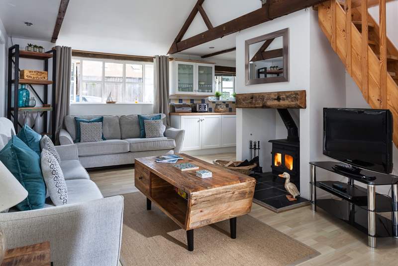 The L-shaped open plan living-room includes a welcoming wood-burner at the centre.