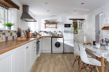 The kitchen and dining-area, with the stable-door at the end opening onto the deck in front of the cottage.