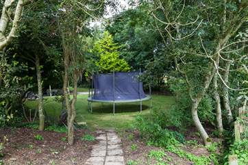 The shared play-area opposite the cottage includes a summer-house and a children's trampoline.