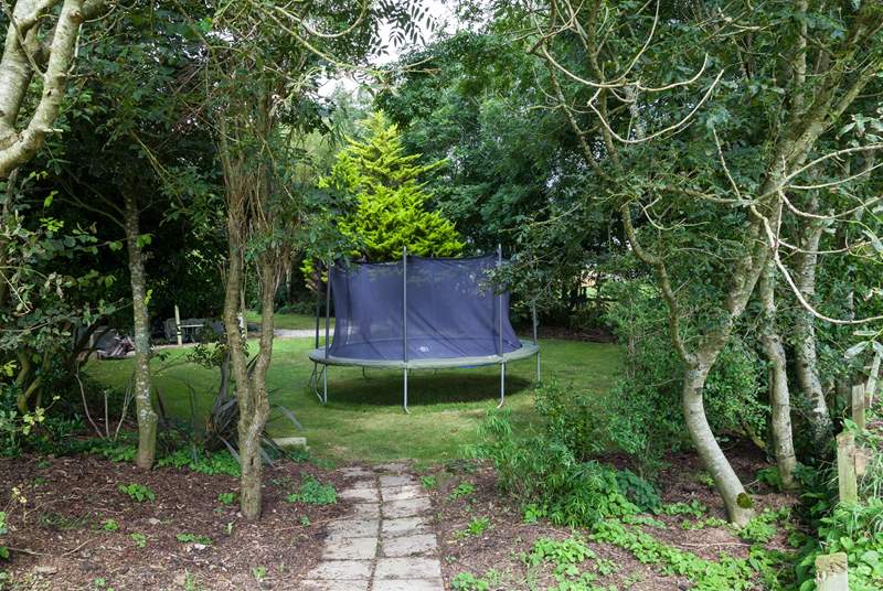 The shared play-area opposite the cottage includes a summer-house and a children's trampoline.