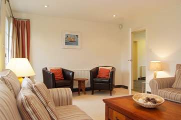 Lovely upholstery, leather tub chairs and beautiful lamps all add to the comfort of the sitting-room.