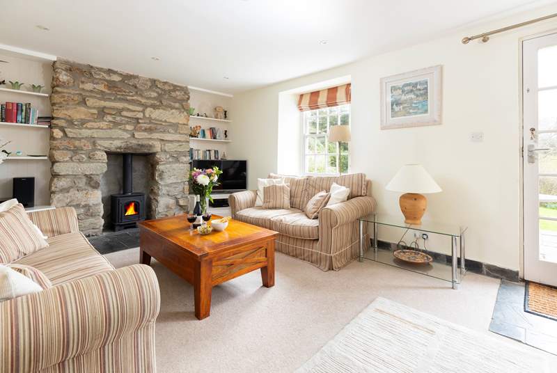 The comfortable sitting room has a cosy wood-burner for the winter months and a door that opens to the sunny terrace. 