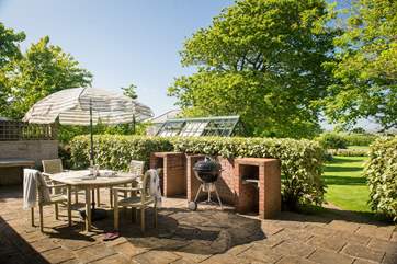 The sunny patio overlooks the large garden.