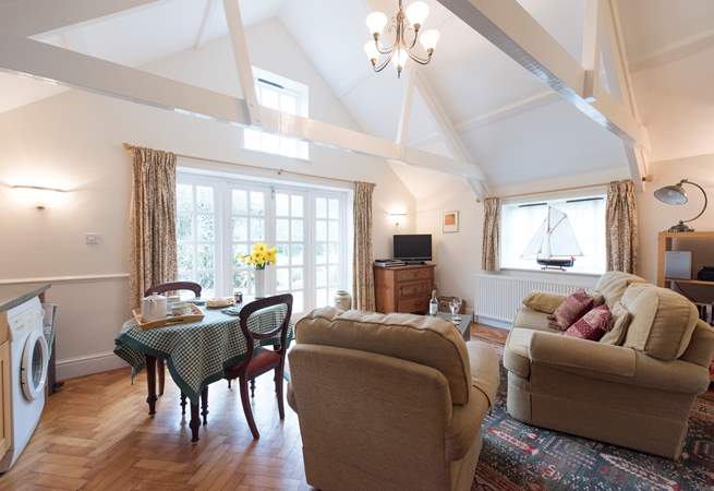 The high apex ceiling has original beams and a high window that allows light to flood in.