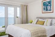 The principal bedroom is furnished in soft yellows and whites.