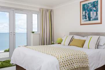 The master bedroom is furnished in soft yellow's and whites.