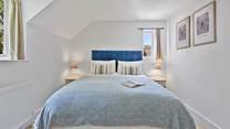 Upstairs, the sumptuous primary bedroom features a king-size bed and en suite bathroom.