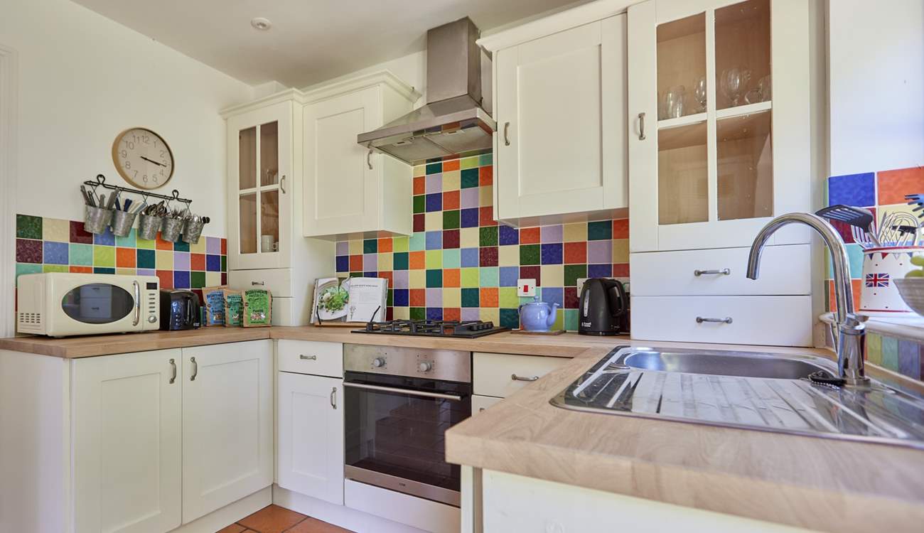 The pretty kitchen is off the sitting-room and overlooking the garden.