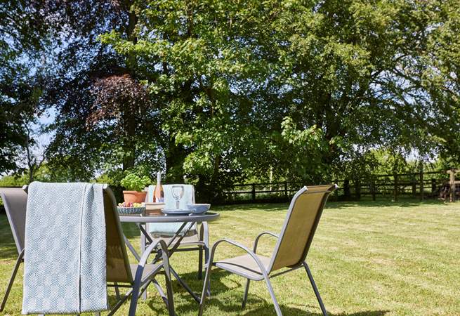 The lovely outdoor table and seating come with a parasol for some relaxing in the shade.