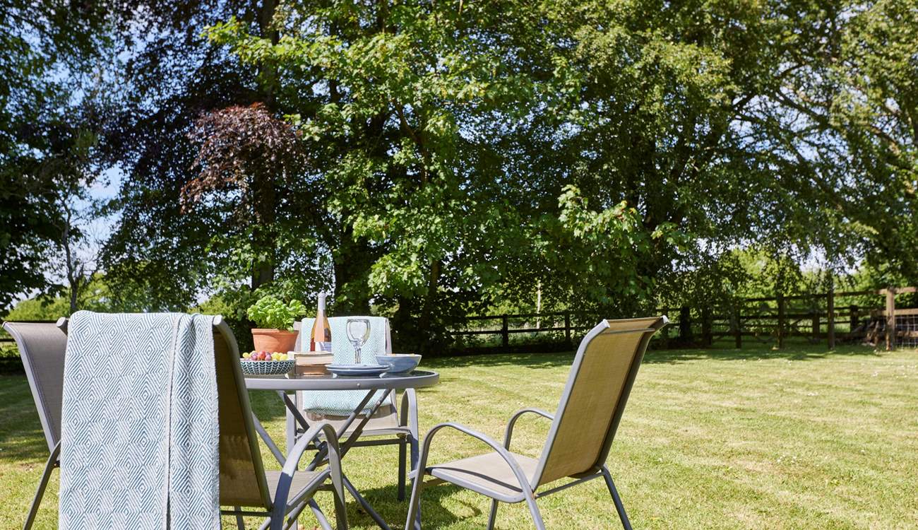 The lovely outdoor table and seating come with a parasol for some relaxing in the shade.