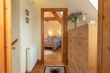 A little landing separates the two bedrooms. More storage space is offered in the large chest of drawers.