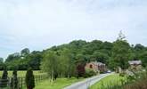 The cottage looks out over the patio and grounds beyond. - Thumbnail Image