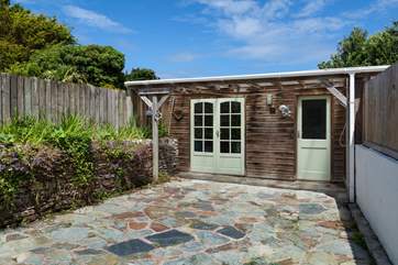 The sunny rear terrace, with a fabulous outside shower. Perfect to wash off the sand after a day on the beach.