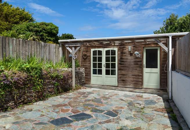The sunny rear terrace, with a fabulous outside shower. Perfect to wash off the sand after a day on the beach.
