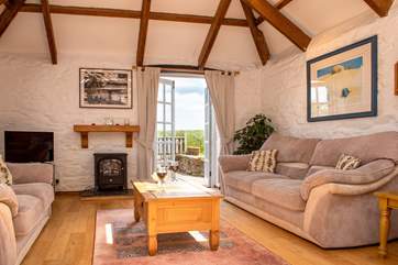 The open plen living space opens up to a terrace overlooking fields.