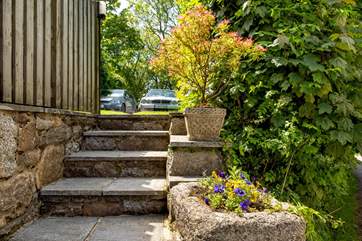 The steps from the front door lead up to the barbecue-area and drive for the barn.