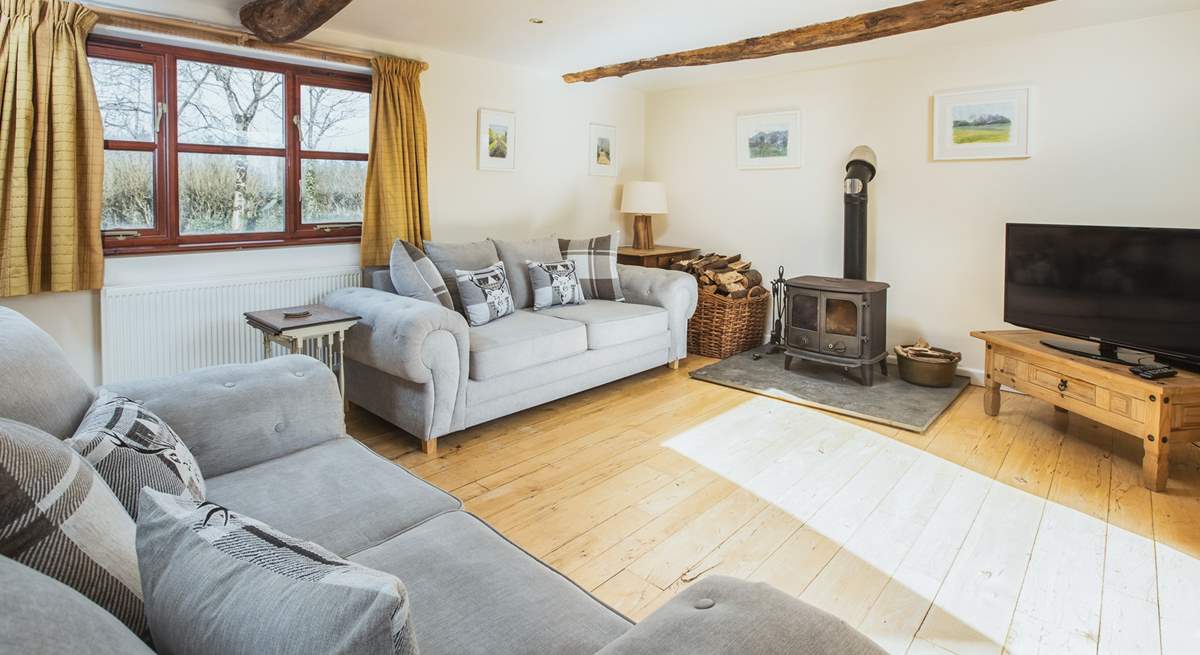 The double aspect sitting-room has views over the garden and the lane and enjoys the joy of a log burner for those cosy nights. 