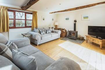 The double aspect sitting-room has views over the garden and the lane and enjoys the joy of a log burner for those cosy nights.