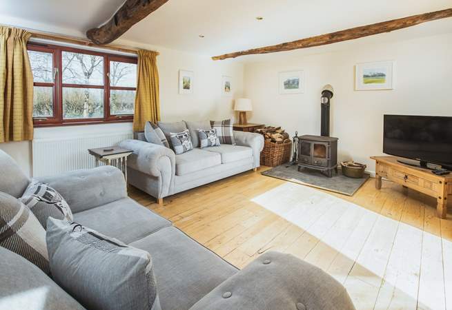 The double aspect sitting-room has views over the garden and the lane and enjoys the joy of a log burner for those cosy nights. 