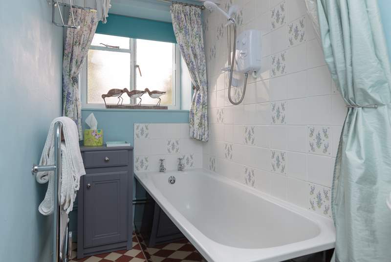 The bathroom is downstairs and has a pretty colour scheme and is a warm and cosy room.