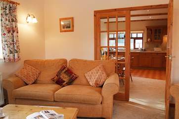 The comfortable sitting-room has double glass doors leading through to the spacious kitchen/dining-room.