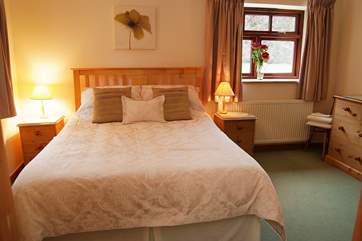The spacious double bedroom (Bedroom 1) is furnished with a king-size bed.