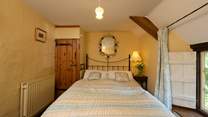 The bedroom with its antique brass bed is on the first floor, at the top of the turning cottage stairs.