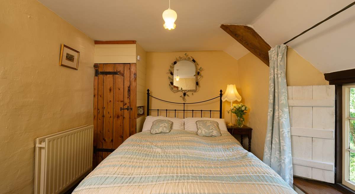 The master bedroom with its antique brass bed is on the first floor, at the top of the turning cottage stairs.