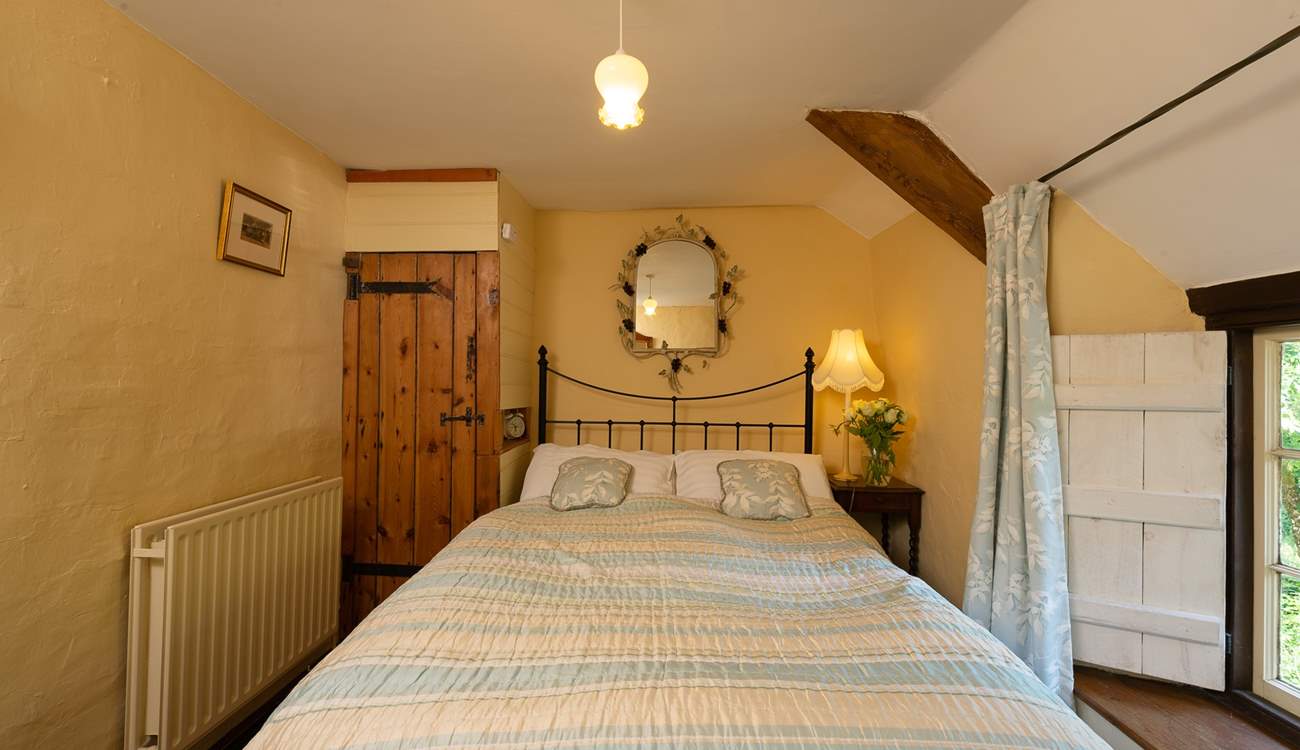 The bedroom with its antique brass bed is on the first floor, at the top of the turning cottage stairs.