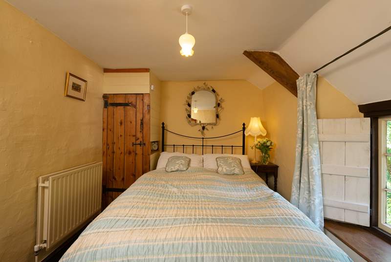 The master bedroom with its antique brass bed is on the first floor, at the top of the turning cottage stairs.