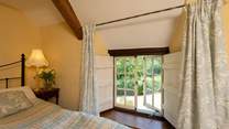 Low window sills and wooden shutters celebrate this wonderful stone cottage.
