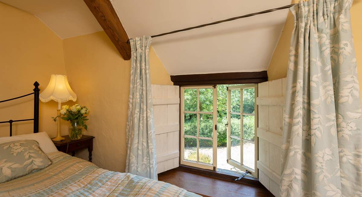 Low window sills and wooden shutters celebrate this wonderful stone cottage.