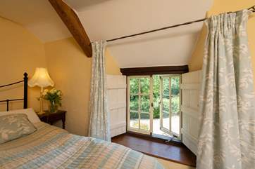 Low window sills and wooden shutters celebrate this wonderful stone cottage.