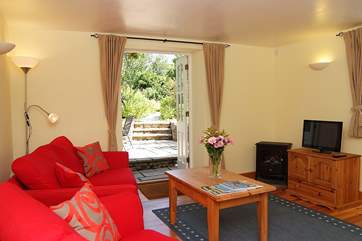 The open plan living-room has French windows out to the patio and walled garden.
