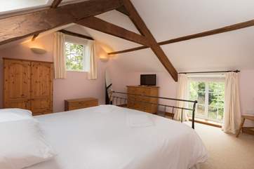 The dual aspect master bedroom has high beamed ceilings and plenty of storage space.