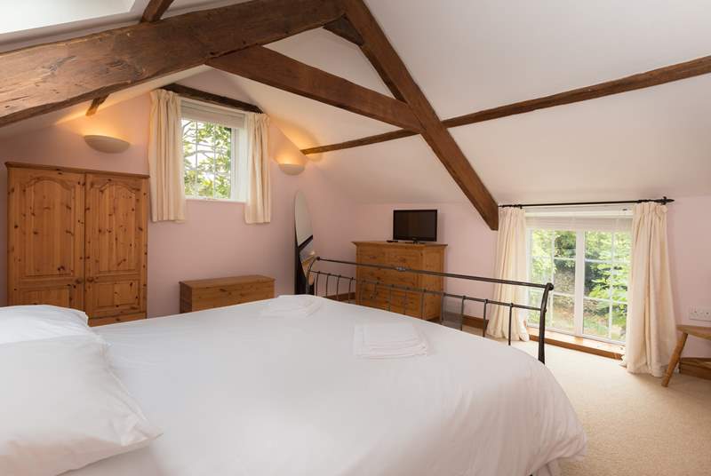 The dual aspect master bedroom has high beamed ceilings and plenty of storage space.