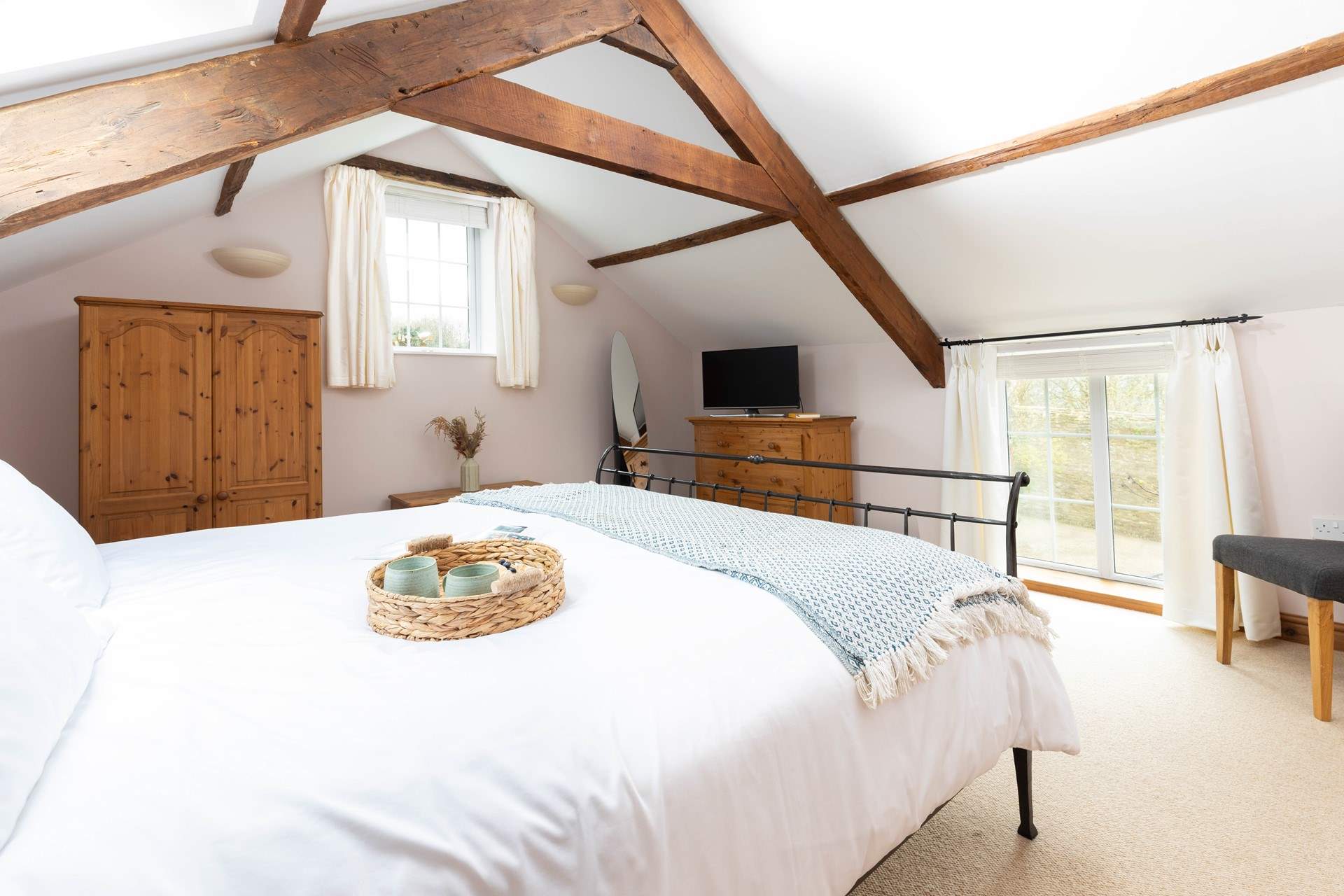 The dual aspect master bedroom has high beamed ceilings and plenty of storage space.