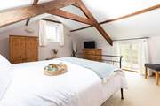 The dual aspect master bedroom has high beamed ceilings and plenty of storage space.